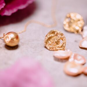 Vertical shot of trendy luxurious golden jewelry on white background